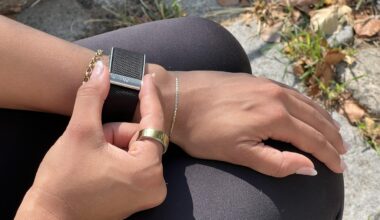 A Whoop 5.0 on a wrist fingers grasping the side indents to get an ECG reading.