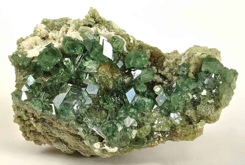Close-up of green fluorite crystals on a mineral matrix for scientific study.