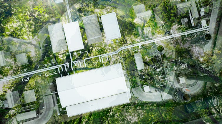 aerial shot of factory, surrounded by green land