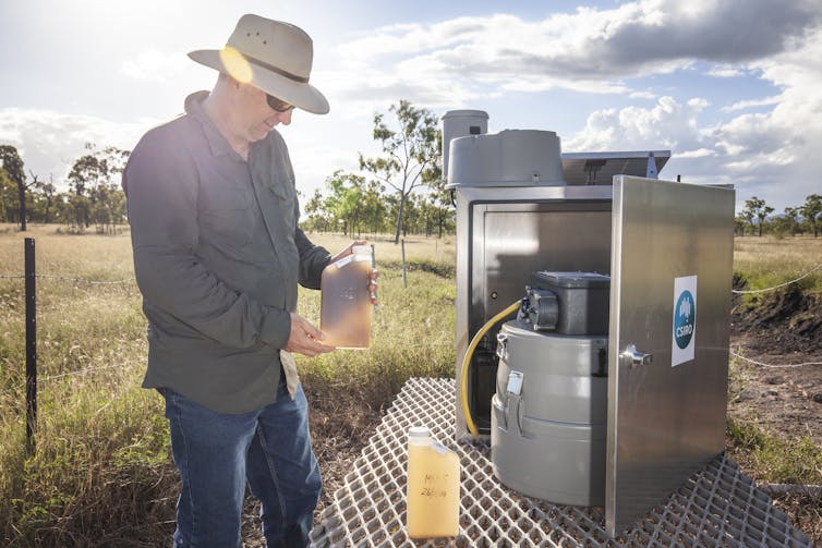 Scientist collecting sediment laden water samples