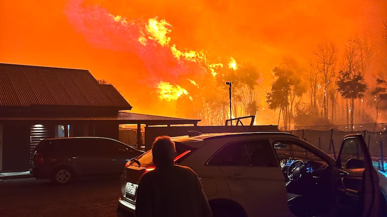 Firefighters work to bring a large blaze under control in Albert Town on Saturday evening, with smoke and flames visible.