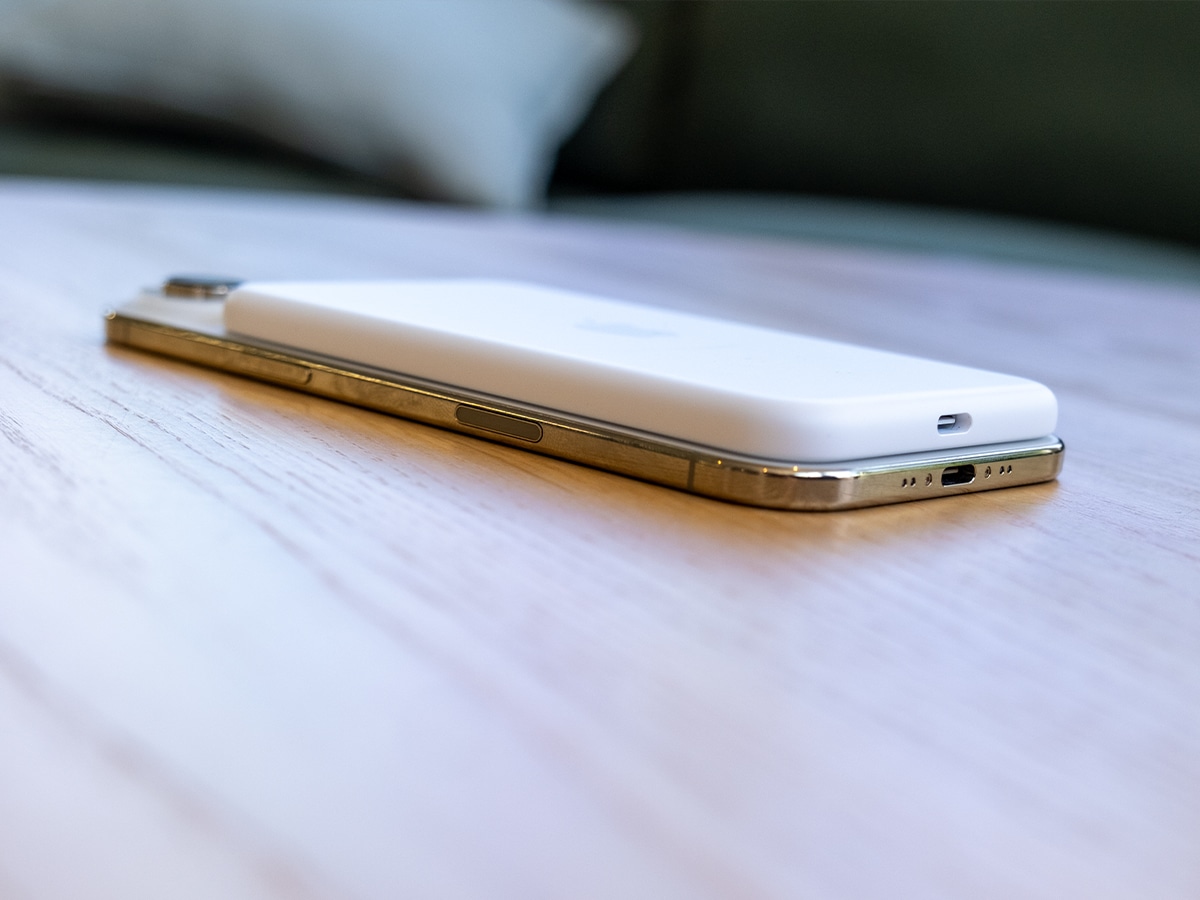 iPhone 17 Air in white with gold edges on a wooden surface, showcasing its slim profile.