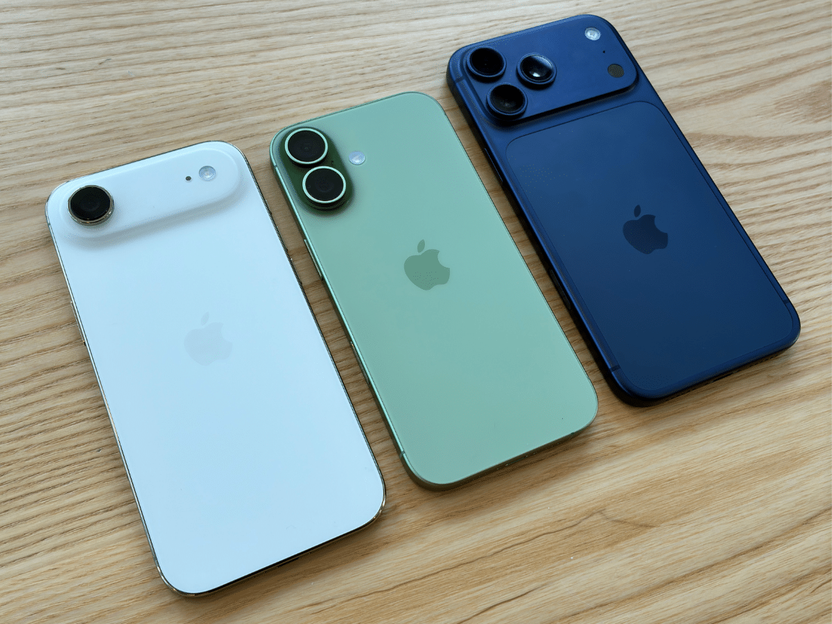 iPhone Air, iPhone 17, and iPhone 17 Air in white, green, and blue on a wooden surface.