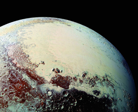 This Pluto mosaic was made from New Horizons LORRI images taken on July 14, 2015, from a distance of 49,700 miles (80,000 km). This view is projected from a point 1,118 miles (1,800 km) above Pluto’s equator, looking northeast over the dark, cratered Cthulhu Regio toward the bright, smooth expanse of icy plains called Sputnik Planum. Pluto’s North Pole is off the image to the left. This mosaic was produced with panchromatic images from the New Horizons LORRI camera, with color overlaid from the Ralph color mapper onboard New Horizons. Image credit: S.A. Stern et al.