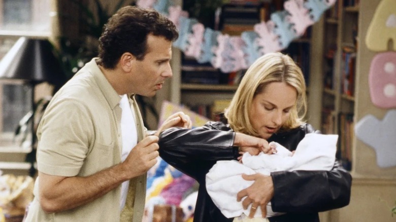Jamie and Paul fussing over their baby in 