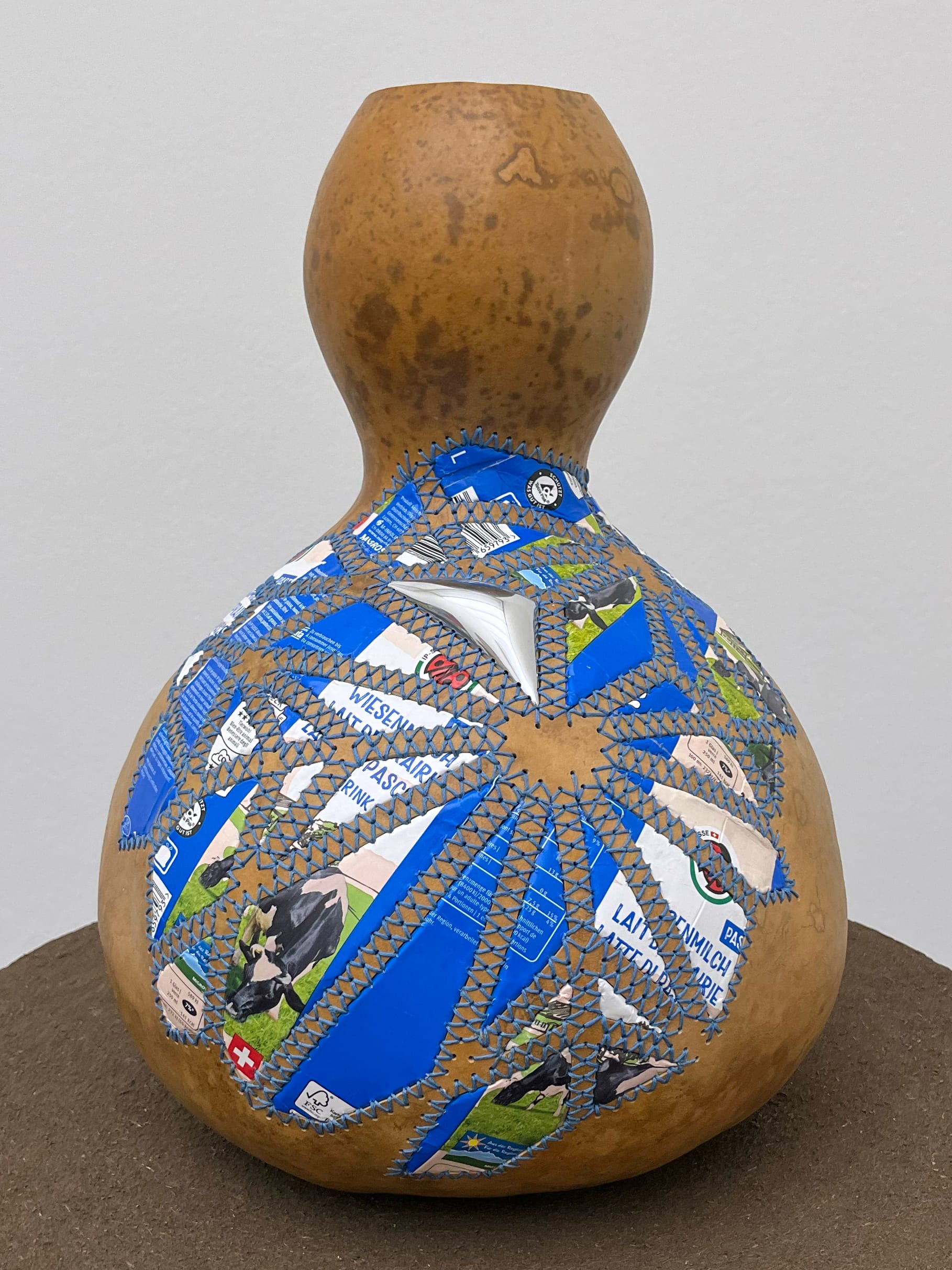 a gourd with colorful aluminum patches sewn on the side