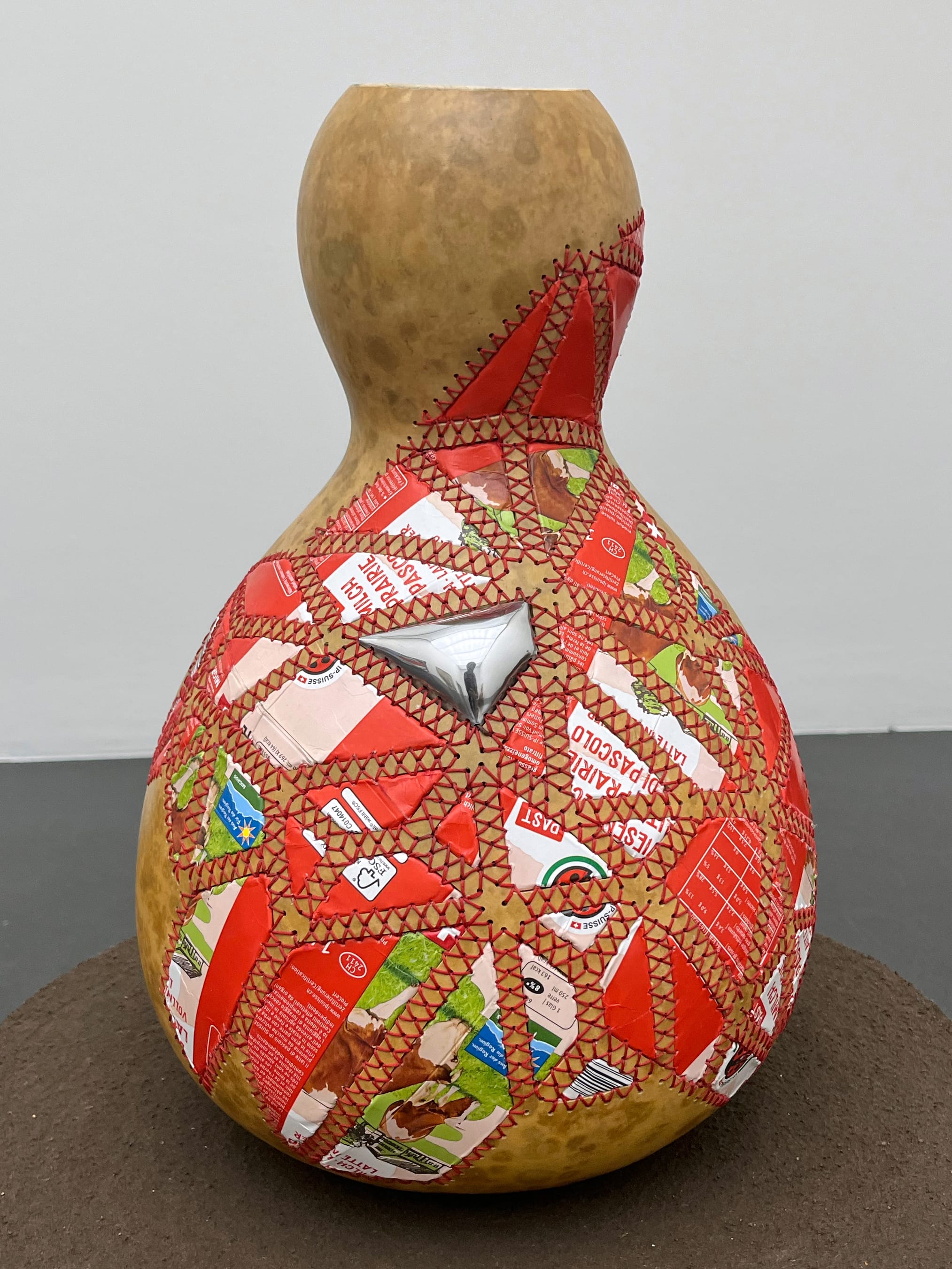 a gourd with colorful aluminum patches sewn on the side