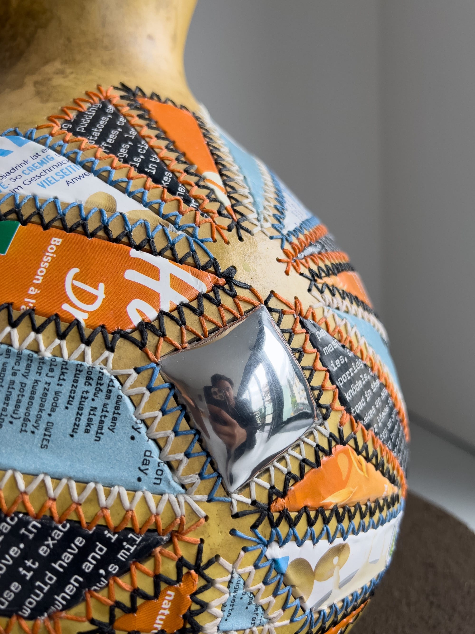 a gourd with colorful aluminum patches sewn on the side