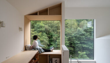 split-level timber house organizes layered interiors around japanese forest