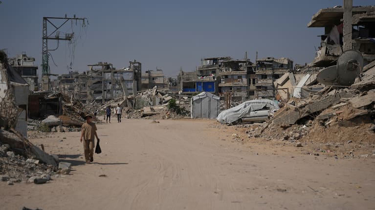 Palestinian walk by the rubble of buildings that were destroyed during the Israel Hamas war, in Khan Younis, southern Gaza Strip, Friday, July 31, 2026.