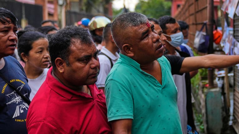People look at photographs of people killed in flash floods displayed outside a government hospital to help relatives identify the victims in Kathmandu, Nepal.