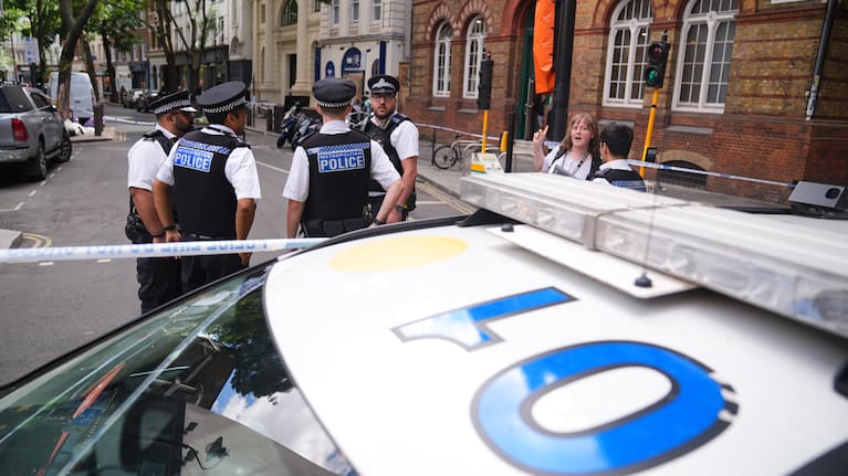 Police officers stand at the scene on Endell Street in Covent Garden, after four men were stabbed, in central London.