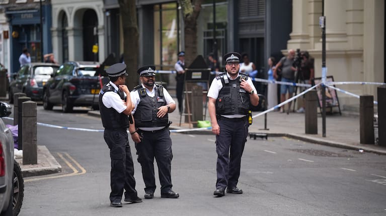 Police officers stand at the scene on Endell Street in Covent Garden, after four men were stabbed, in central London.