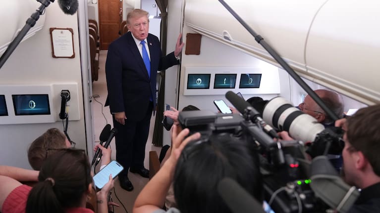 President Donald Trump speaks to reporters onboard Air Force One.