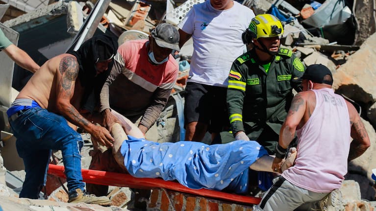 Residents and police carry a survivor pulled from the rubble after an earthquake struck Pereira, Colombia