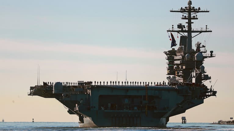 Sailors and Marines line the deck of aircraft carrier USS Abraham Lincoln (CVN-72) as it deploys from San Diego, Jan. 3, 2021