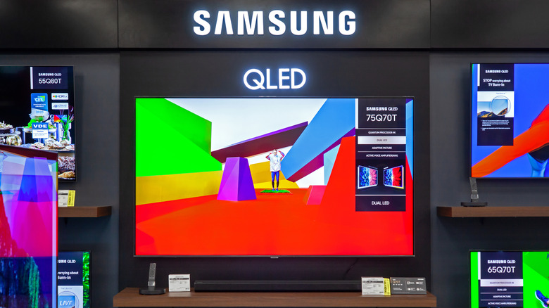 A Samsung smart TV on display beneath Samsung signage