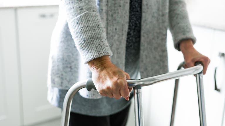 Senior woman using walker at home stock photo.