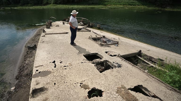 Stanislav Kozenko stands on the wreckage of an old steam boat, known as the Slovenian.