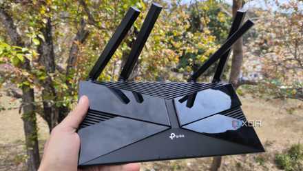 A person holding a TP-Link router