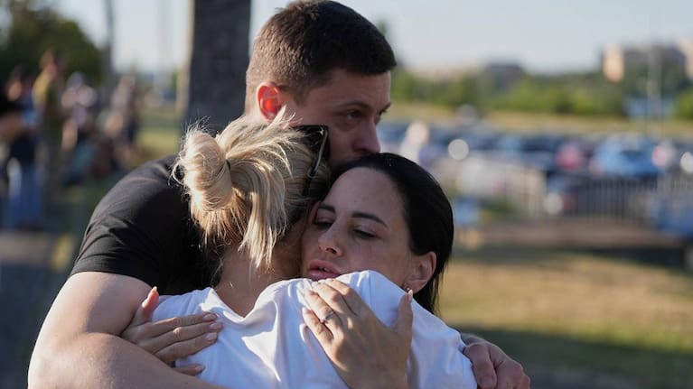 Shoppers and families embrace one another after being evacuated from the struck shopping centre.