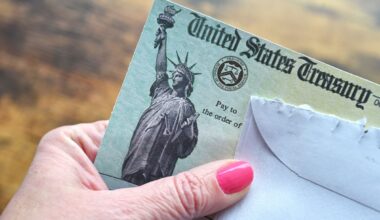 A hand is holding a Social Security check issued by the U.S. Treasury.