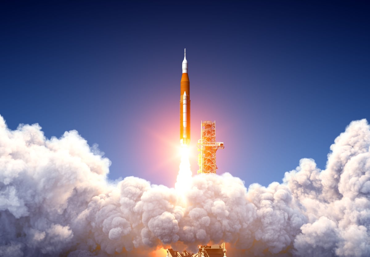 A rocket is lifting off of a launchpad.