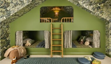 a vaulted attic room with tree wallpaper across walls and ceiling with a custom green painted triple bunk bed for kids