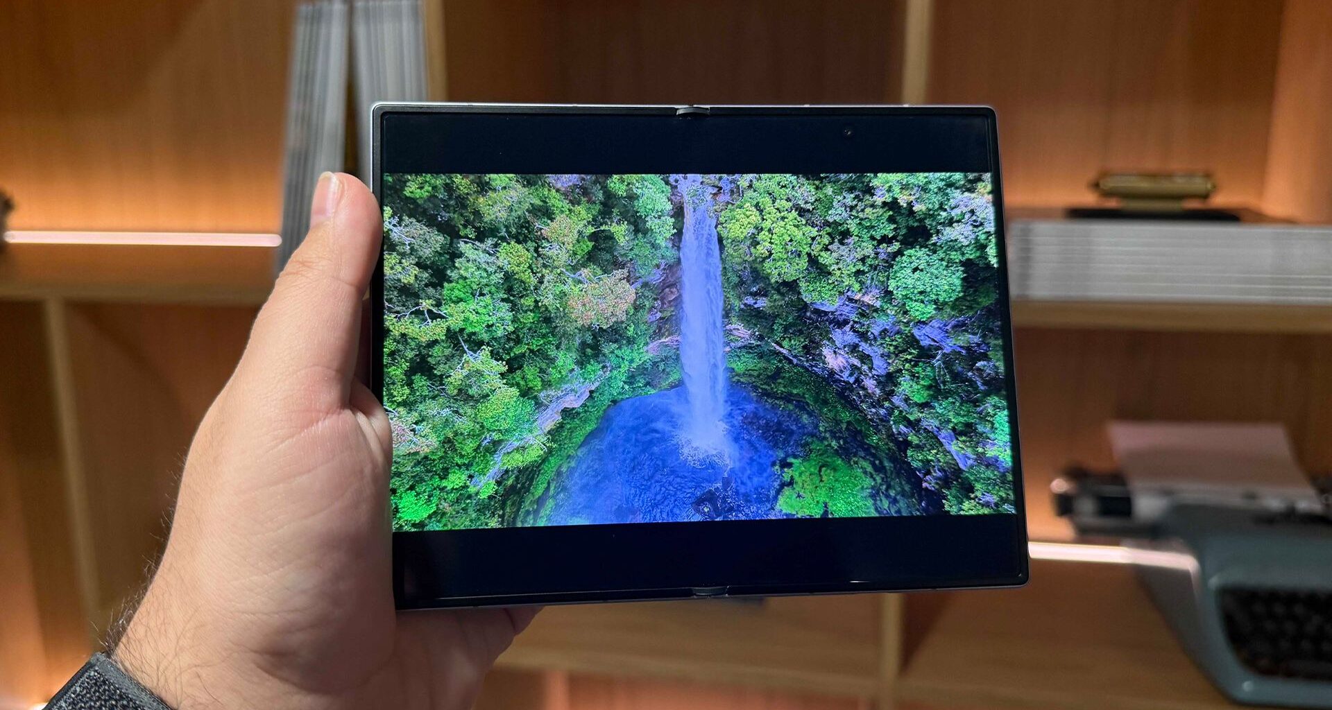 Samsung Galaxy Z Fold 8 smartphone held in hand unfolded, on screen is waterfall