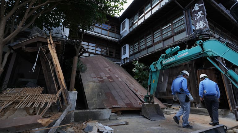 Workers inspect debris of the Kinparo inn, founded in 1910, for conservation of a possible rebuilding in Yatsushiro, southern Japan, Friday, July 31, 2026, three days after an earthquake hit the area.