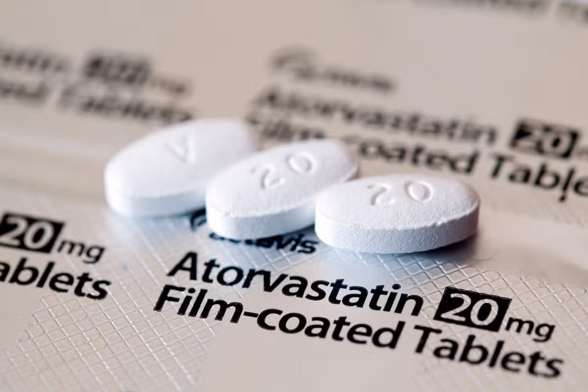 Aberdeen, Scotland - April 7, 2014: Close up view of three Atorvastatin tablets.  Atorvastatin is a member of the drug class known as statins, used for lowering blood cholesterol levels.