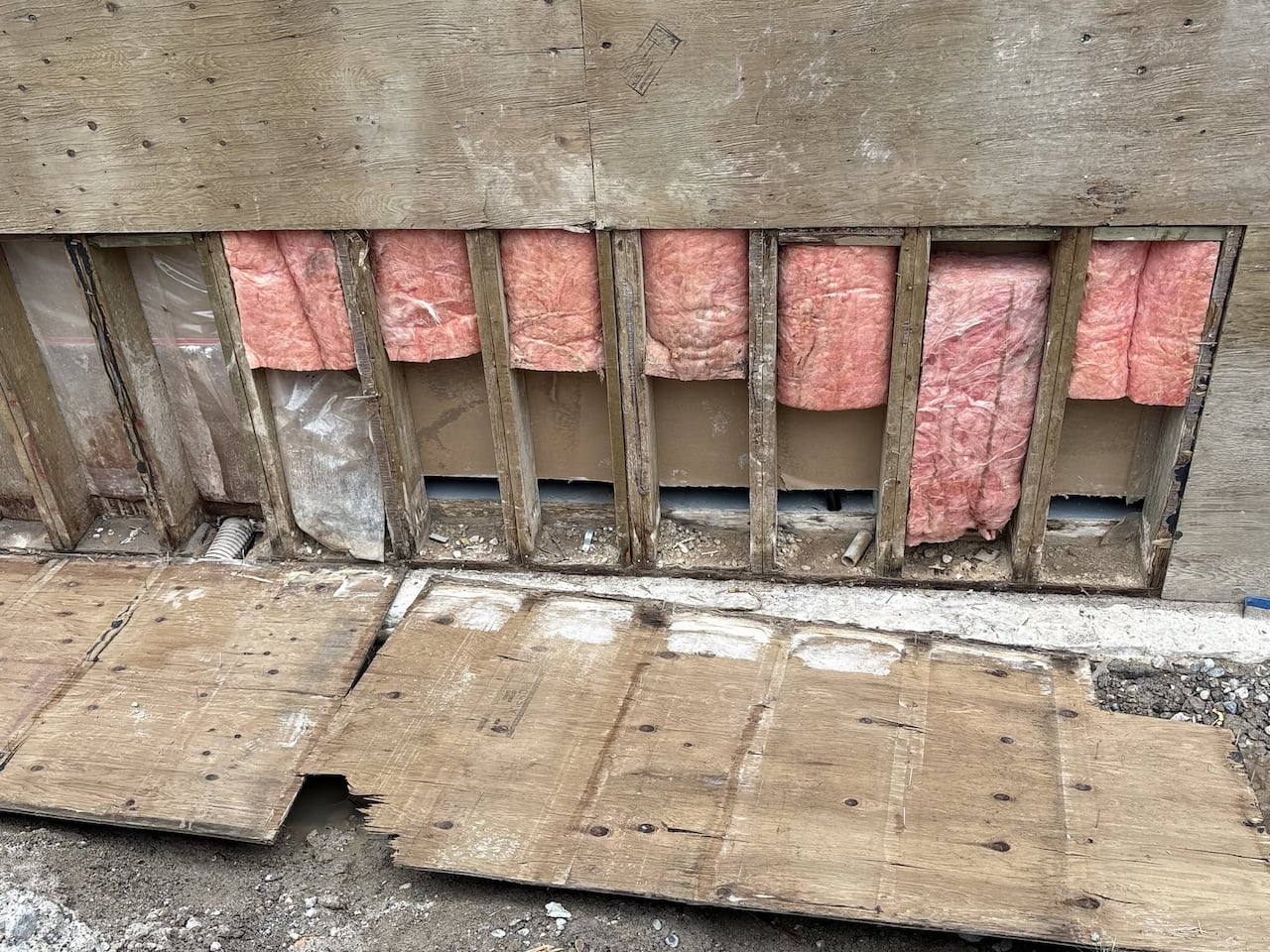 Pink insulation is seen in a wall.