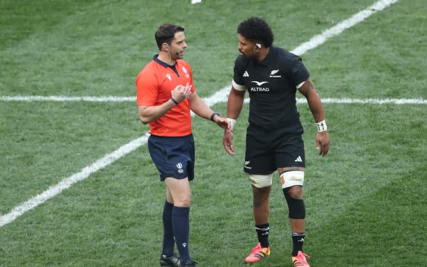 Referee Nika Amashukeli talks to Ardie Savea.