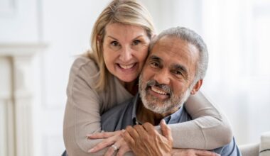 Wife hugging husband, with both smiling.