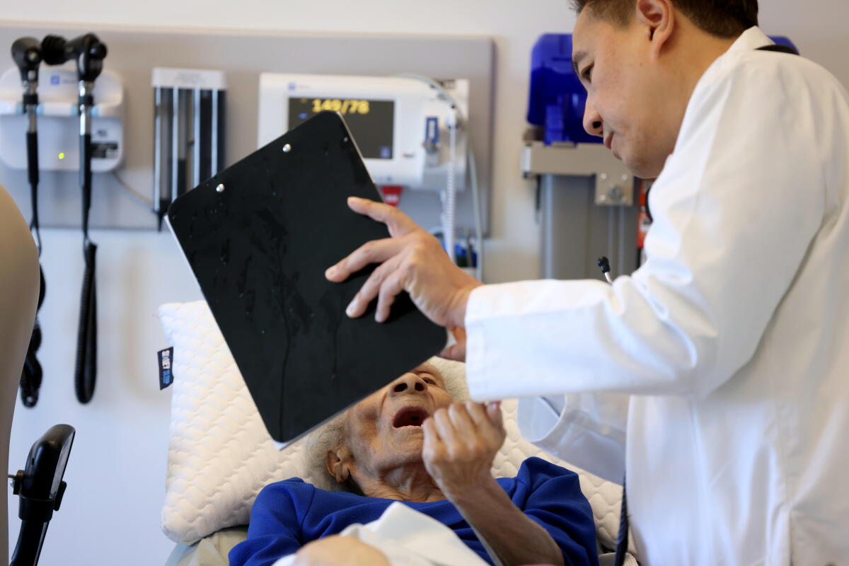 A doctor asks a patient to identify animals on a chart