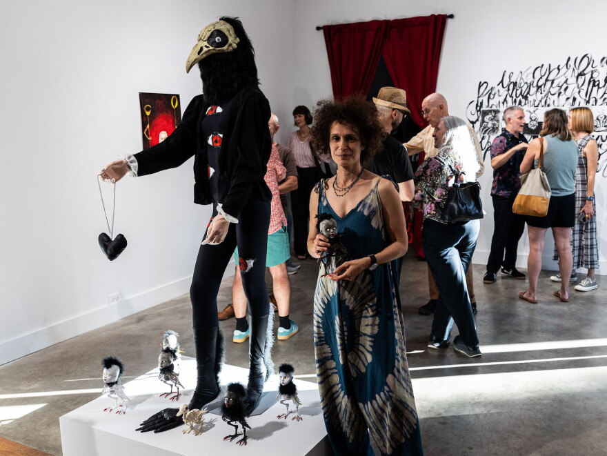 Yuliya Lanina poses for a portrait in front of her exhibit at grayDUCK gallery’s closing party in Austin, Texas on Sept. 26, 2026.