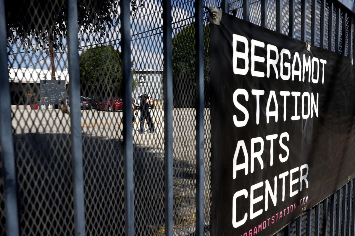 A woman walks past the main gate at Bergamot Station Arts Center.