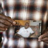 A close-up photo shows Leslie Adams' hands holding a snapshot of his mother. She is smiling broadly.