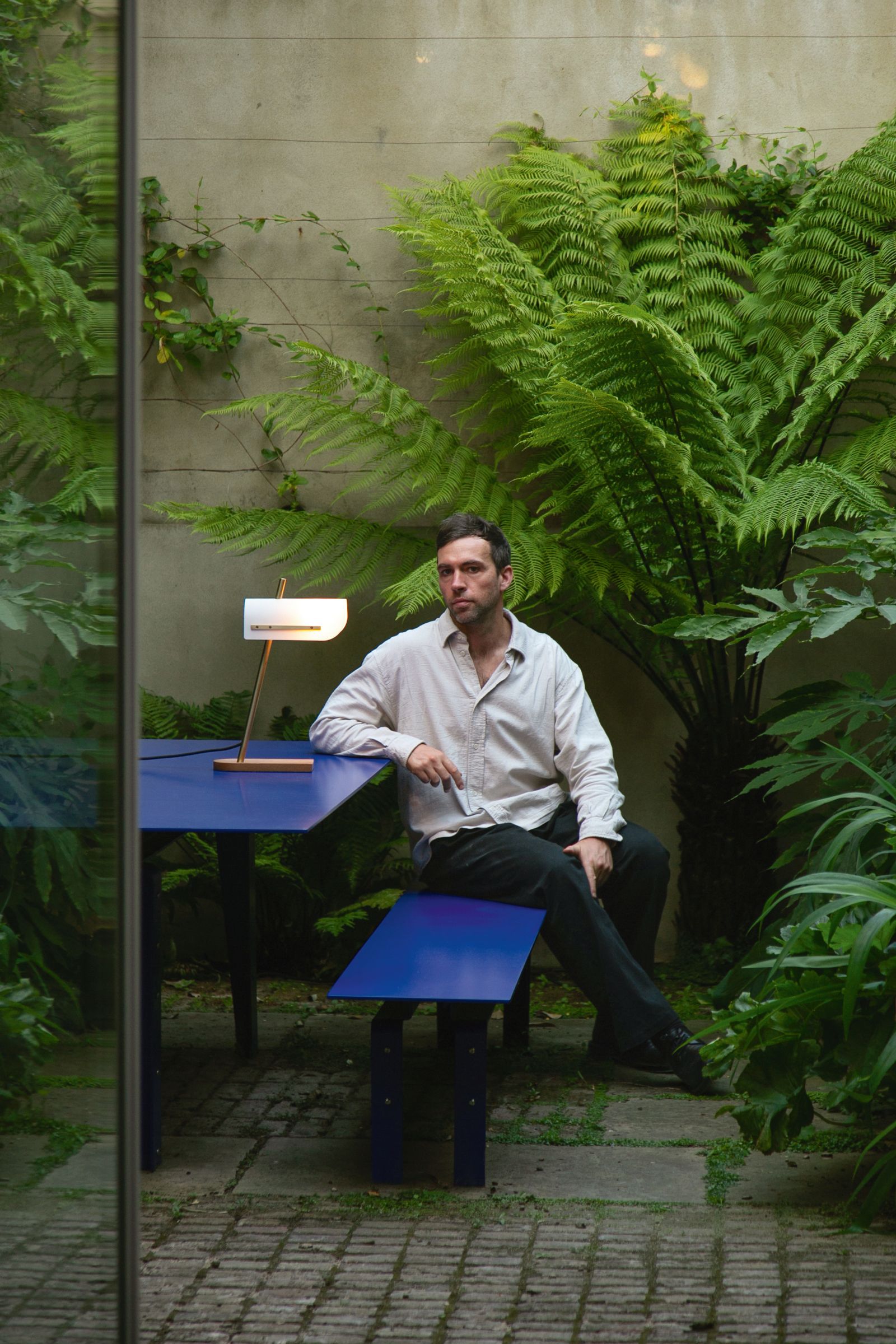 Image may contain Person Sitting Furniture Table Adult Face Head Photography Portrait Fern Plant Desk and Tree