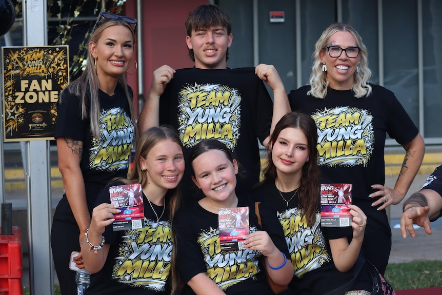 A group of six people wearing black T-shirts with 'Team Yung Milla' written on them, smiling.