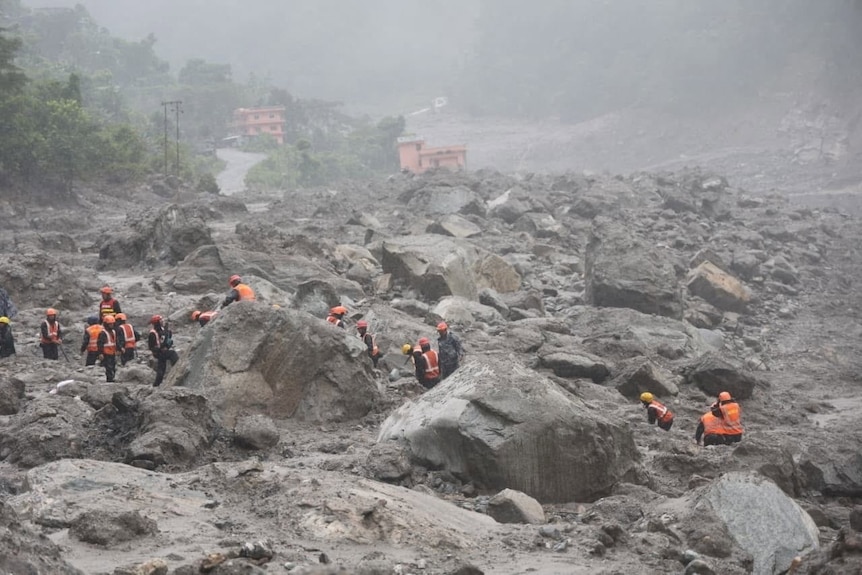 Lots of rescue workers searching through debris near the hydropower project tunnel