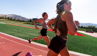 two women running on a red track