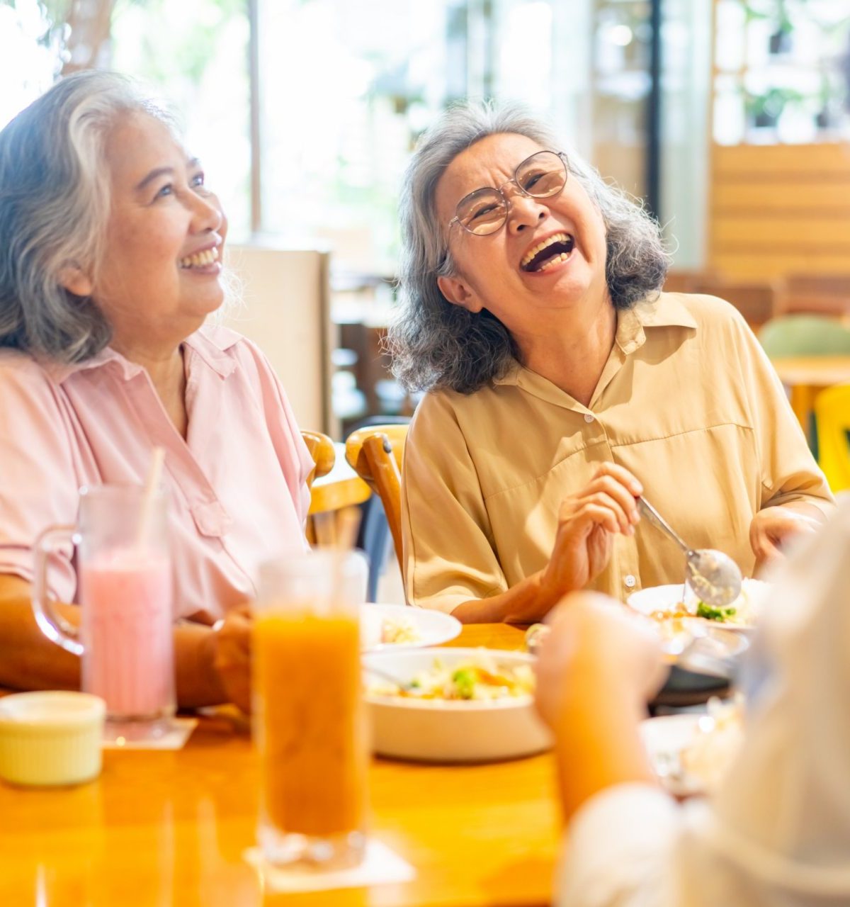 Group of Happy Asian senior women friends shopping and having lunch at restaurant on summer holiday vacation. Healthy elderly woman enjoy outdoor lifestyle meeting and eating food together.