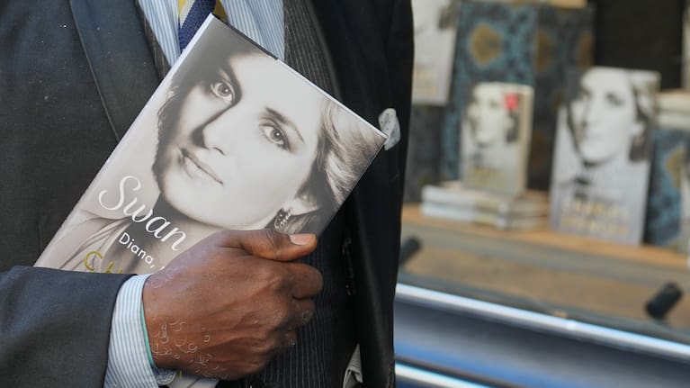 A man holds a copy of the new book by Earl Spencer, brother of the late Princess Diana, entitled "Swan Song: Diana, My Sister,".