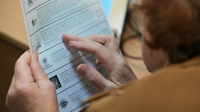 A voter looks through a ballot during the parliamentary election in Moscow, Sunday, Sept. 20, 2026.