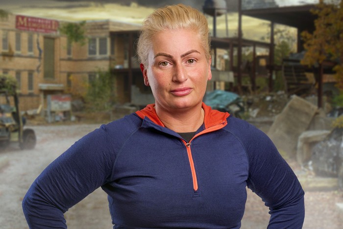A woman stood smiling with her hands on her hips.