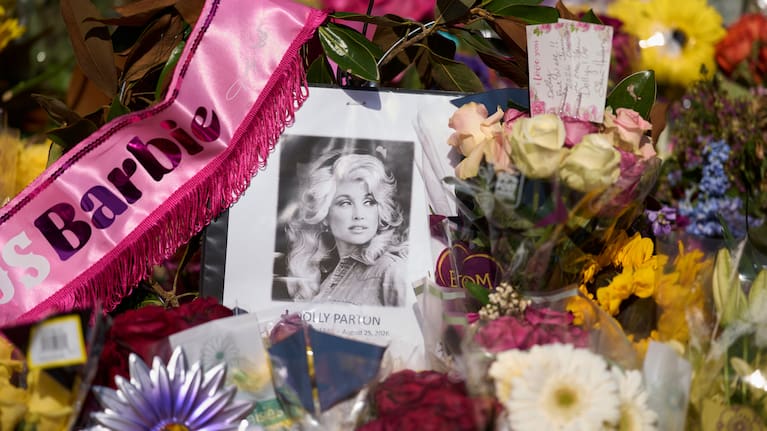 A portrait of the late Dolly Parton surrounded by flowers and cards in a memorial sits outside her home Thursday, Aug. 27, 2026