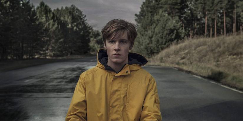 Louis Hofmann as Jonas wearing a yellow jacket on a road in Dark
