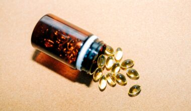 Fish oil, vitamin d, omega 3 capsules are spilling from brown plastic bottle on beige background