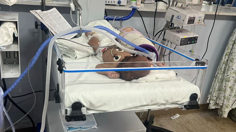 A bible is placed at the end of a baby's hospital bed.